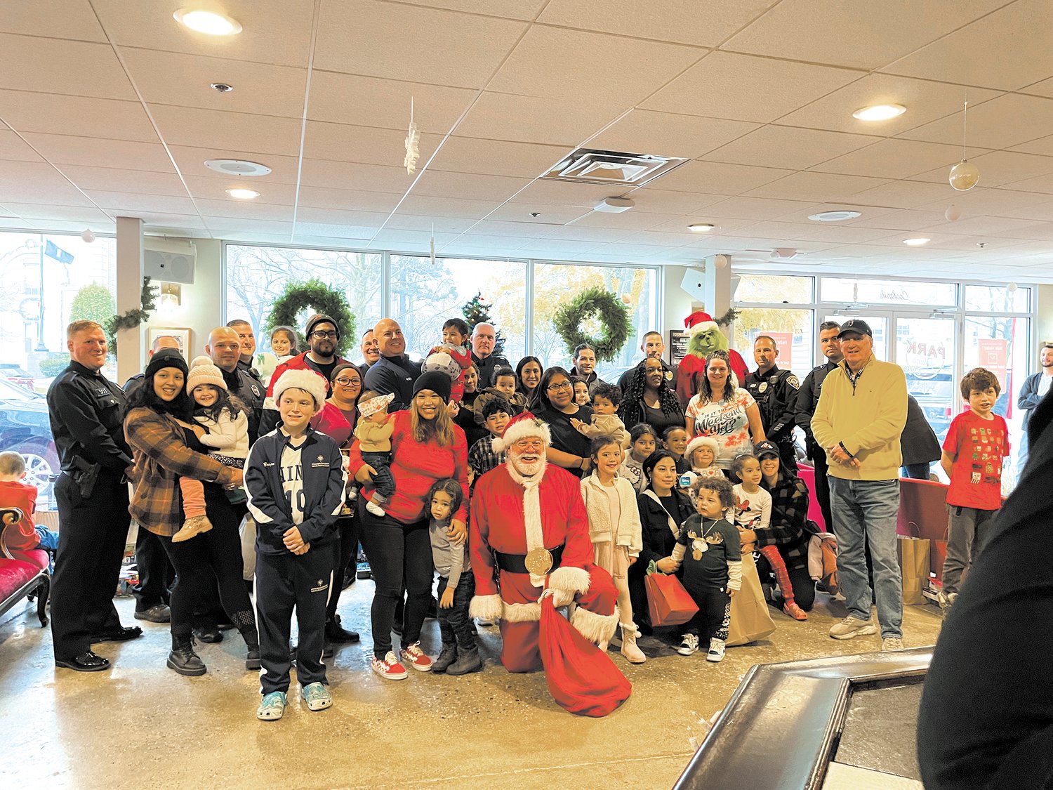 ALL TOGETHER: Santa, members of CPD and Cranston Cares, Mayor Hopkins, CCAP and the families who attended the holiday party all pose for a quick photo.